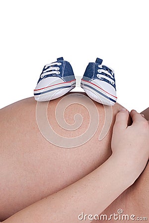 Closeup of a pregnant woman with blue baby shoes Stock Photo