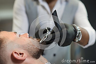Closeup of process of cutting beard of client in barber shop Stock Photo
