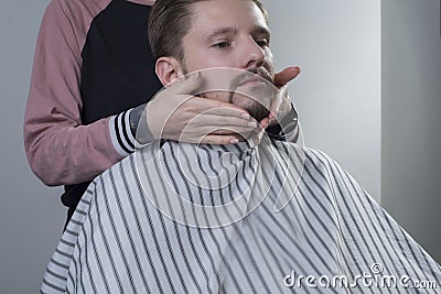 Closeup process of haircut and beard care. A professional master prepares a clients beard for cutting and shaving a beard. Makes Stock Photo