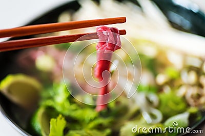 Closeup of raw piece of beef meat ready to be cooked in the hot soup Stock Photo