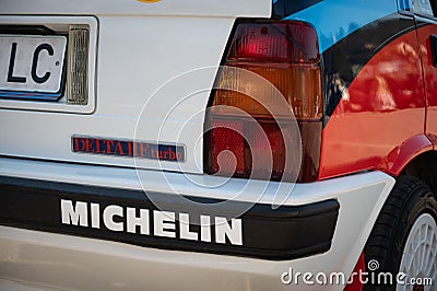 Closeup of the rear view of a Lancia Delta HF covered in a sticker Michelin parked on the street Editorial Stock Photo