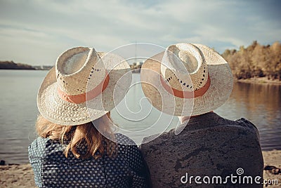 Closeup rear view of man and woman sitting on the beach and loo Stock Photo