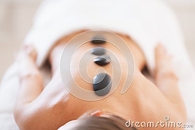 Closeup on relaxed young woman receiving hot stone massage Stock Photo
