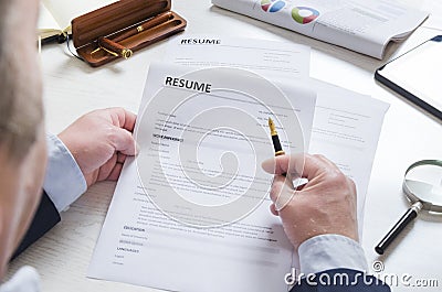 Closeup of resume paper and recruiter who exploring it.Concept of searching and hiring new employees Stock Photo