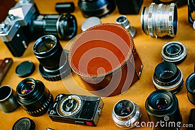 Closeup retro mockup, round leather vintage box in center and vintage photographic accessories and quipments around on wooden Stock Photo