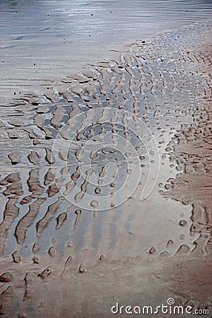 Closeup of the rippled patterns of water and sand Stock Photo