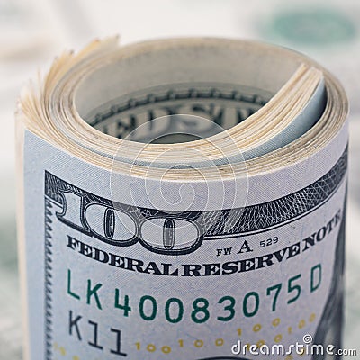 Closeup rolled dollar hundred on background American money dollar bill. Many US 100 banknote Stock Photo