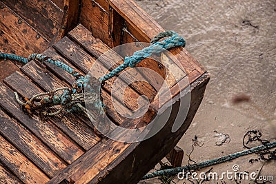 Closeup of a rotten, stranded boat with distorted knots of ropes Stock Photo