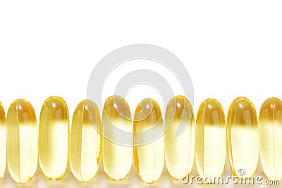 Closeup row of capsules fish oil with Omega 3 on white background. Seamless pattern. Stock Photo