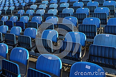 Closeup of rows of blue folded chairs at a stadium Stock Photo