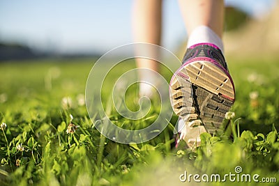 Closeup runner feet running outdoors on the green grass. Fitness. Stock Photo
