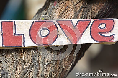 Closeup of rustic wooden love sign hooked on a tree, Peru Stock Photo