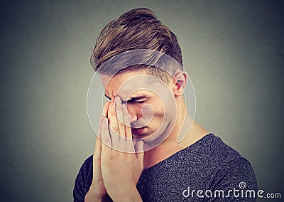 Sad young man with tensed face expression praying Stock Photo