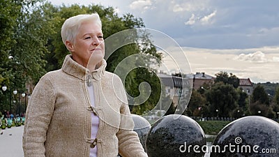 Closeup sad serious attractive 65s woman of retirement age. Calm brooding mature lady in casual clothes with gray Stock Photo