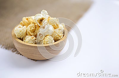 Closeup salted popcorn in round wooden bowl on white background Stock Photo