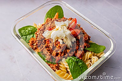 Closeup of a savory mixture of noodles and diced meat on the transparent plate Stock Photo