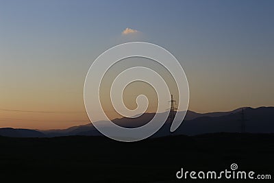 Closeup of scenic nature at sunset, powerlines, and hills on the background Stock Photo