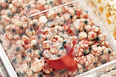 Closeup of scoop filled with eye form candy, sweets in transparent box in tuck shop.Halloween Stock Photo