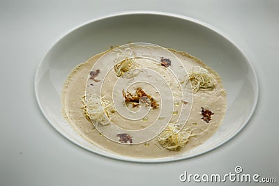 Closeup seafood cream soup decorated with dried squid and soy sauce Stock Photo