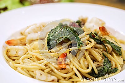 Closeup seafood stir fried spicy spaghetti in white ceramic plate Stock Photo