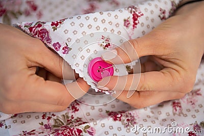 Closeup on seamstress sewing button Stock Photo