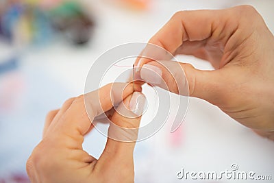 Closeup on seamstress threading needle Stock Photo