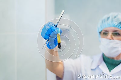 Closeup of a senior female chemist setting up some sample blood tubes inside a centrifuge for some test in a lab. Stock Photo