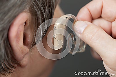 Closeup senior woman using hearing aid Stock Photo