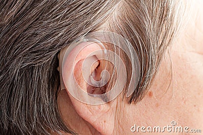 Closeup senior woman using hearing aid Stock Photo