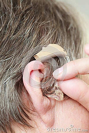 Closeup senior woman using hearing aid Stock Photo