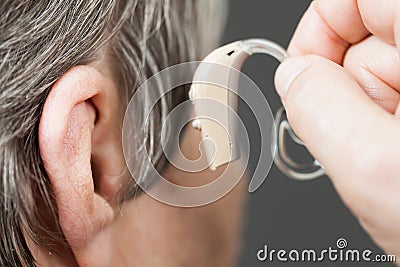 Closeup senior woman using hearing aid Stock Photo