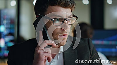 Closeup serious businessman call client in dark office. Thoughtful man manager Stock Photo