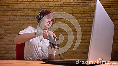 Closeup shoot of young teenage hipster female video blogger playing video games on the laptop with heat and ardor Stock Photo