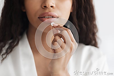 Closeup shot of african american lady taking white round pill, suffering from acute headache or migraine, crop Stock Photo