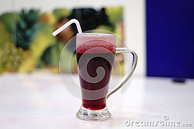 Closeup shot of Arabian juice of Jallab with straw in big glass with blur background Stock Photo