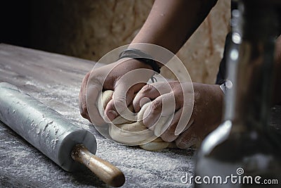 Closeup shot of a baker mixing the dough with flour Stock Photo