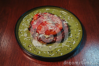 Closeup shot of beautifully served meat dish on a green plate Stock Photo