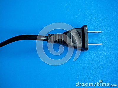 Closeup shot of a black American plug on a blue surface Stock Photo