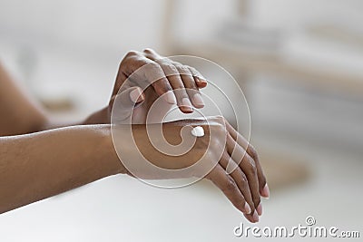 Closeup Shot Of Black Lady Applying Drop Of Moisturising Cream On Hands Stock Photo
