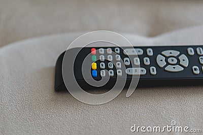 Closeup shot of a black plastic television remote on the sofa Stock Photo