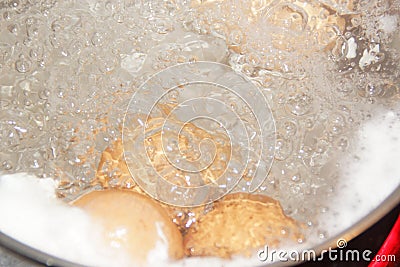 Closeup shot of boiling water with brown eggs on a stainless casserole Stock Photo