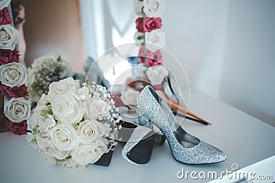 Closeup shot of a bouquet and sparkly shoes on a vanity Stock Photo
