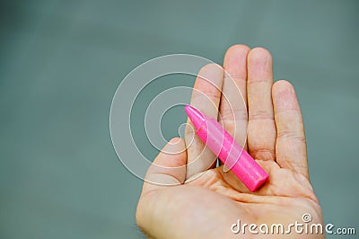 Closeup shot of a broken pink crayon on a hand Stock Photo