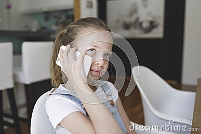 Closeup shot of a caucasian female child speaking on the phone at home Stock Photo