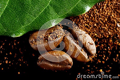 Closeup shot of coffee powder,beans with green leaf on black Stock Photo