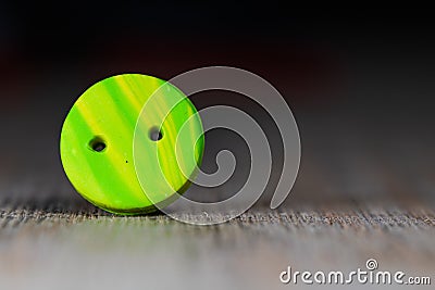 Closeup shot of a colorful button put on a wooden surface Stock Photo