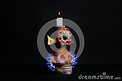 Closeup shot of a colorful clay candlestick skull on a black background Stock Photo