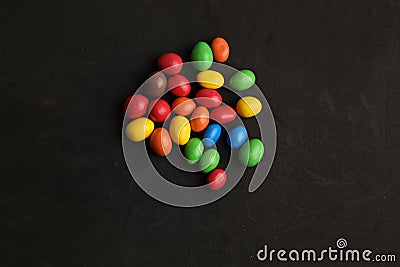 Closeup shot of colorful coated chocolate candies isolated on a black background Stock Photo