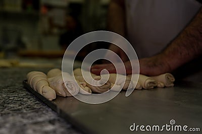 Closeup shot of conch shaped croissants on a tray before being baked in a bakery Stock Photo
