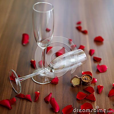 Closeup shot of a couple of glasses of champagne and red roses on a wooden table Stock Photo